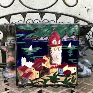 Antieke polychrome wandtegel – Dorp aan zee, ca. 1900