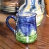 Charmant Vlaams melkkannetje in levendig blauw‑groen aardewerk | Charming Flemish blue‑green glazed milk jug – vintage earthenware